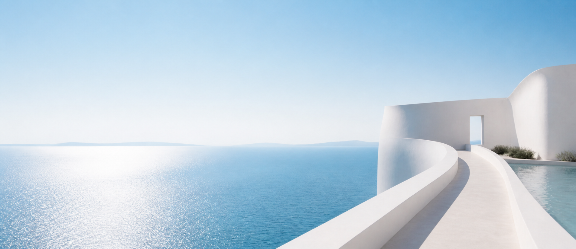 White architectural paths and walls extending across blue water toward the horizon